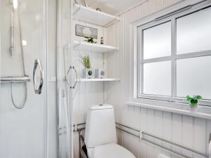 a white bathroom with a toilet and a window at Holiday Home Imma - from the sea in NE Jutland by Interhome in Hals