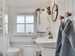 a white bathroom with a sink and a toilet at Holiday Home Imma - from the sea in NE Jutland by Interhome in Hals