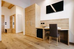 Cette chambre comprend un bureau avec une chaise et une télévision. dans l'établissement Hotel Aurai, à Telve