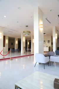 a lobby with white chairs and a chandelier at Golden Bujari Bisha جولدن بوجاري بيشة in Qal'at Bishah