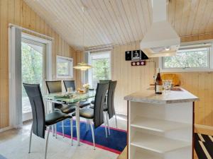 a kitchen and dining room with a table and chairs at Holiday Home Jussi - 3-5km from the sea in NW Jutland by Interhome in Brovst