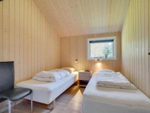 two beds in a room with a window at Holiday Home Jussi - 3-5km from the sea in NW Jutland by Interhome in Brovst