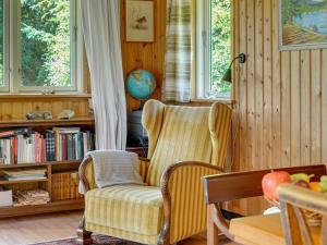 a living room with a chair and a book shelf at Holiday Home Lennert - 100m to the inlet in The Liim Fiord by Interhome in Åbybro