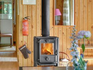 a wood stove in a living room with a fire at Holiday Home Lennert - 100m to the inlet in The Liim Fiord by Interhome in Åbybro
