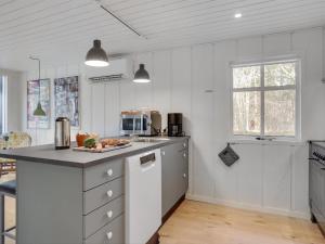 une cuisine avec des placards blancs et un comptoir dans l'établissement Holiday Home Marise - from the sea in NE Jutland by Interhome, à Hals