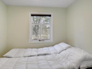- un lit blanc dans une chambre avec fenêtre dans l'établissement Holiday Home Marise - from the sea in NE Jutland by Interhome, à Hals