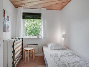 um pequeno quarto com uma cama e uma janela em Holiday Home Kerttuli - 800m from the sea in NE Jutland by Interhome em Hadsund