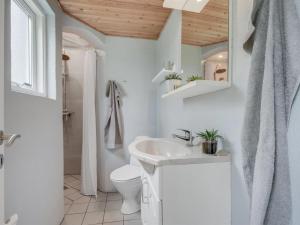 uma casa de banho branca com um lavatório e um WC em Holiday Home Kerttuli - 800m from the sea in NE Jutland by Interhome em Hadsund