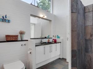 La salle de bains blanche est pourvue d'un lavabo et de toilettes. dans l'établissement Holiday Home Angelarij - all inclusive - from the sea by Interhome, à Hadsund