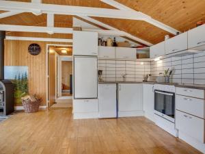 a kitchen with white appliances and a wooden ceiling at Holiday Home Herdina - 4km from the sea in NW Jutland by Interhome in Brovst