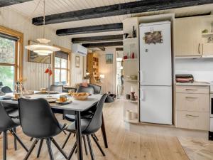 a kitchen and dining room with a white refrigerator at Holiday Home Marite - 200m from the sea in NW Jutland by Interhome in Pandrup