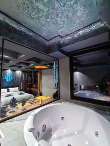 een groot bad in een kamer met een slaapkamer bij Smart Luxury Penthouse Suites - Private Sauna, Hot-Tub, Home Cinema at the best Location in Skopje in Skopje