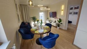 uma sala de jantar com uma mesa e cadeiras azuis em Apartament Nr 50, 2 sypialnie, wygodny parking podziemny em Toruń