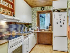 Holiday Home Carina - 5km from the sea in NW Jutland by Interhome في Brovst: مطبخ مع ادوات بيضاء وثلاجة بيضاء