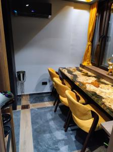 einen Tagungsraum mit einem Tisch und gelben Stühlen in der Unterkunft Smart Luxury Penthouse Suites - Private Sauna, Hot-Tub, Home Cinema at the best Location in Skopje in Skopje