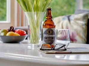 una botella de cerveza sentada en una mesa con gafas en Holiday Home Krister - 250m to the inlet in The Liim Fiord by Interhome en Farsø