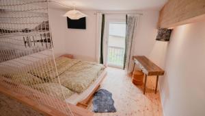 Schlafzimmer mit einem Bett, einem Schreibtisch und einem Fenster in der Unterkunft fewoflagmeier Kohlstetten II Alte Schreinerei in Kohlstetten