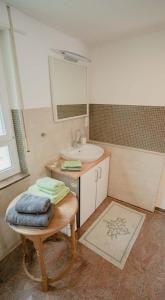 ein Badezimmer mit einem Waschbecken, einem Spiegel und einem Tisch in der Unterkunft fewoflagmeier Kohlstetten II Alte Schreinerei in Kohlstetten