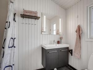 ein Bad mit einem Waschbecken und einem Spiegel in der Unterkunft Holiday Home Driss - all inclusive - 500m from the sea by Interhome in Pandrup