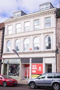 a white building with cars parked in front of it at STUNNING 3 Double Bedroom Apartment - *Town Centre / Near Beach* in Berwick-Upon-Tweed