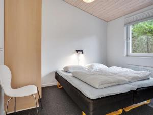 - une chambre avec un lit, une chaise et une fenêtre dans l'établissement Holiday Home Awenita - 50m to the inlet in The Liim Fiord by Interhome, à Løgsted