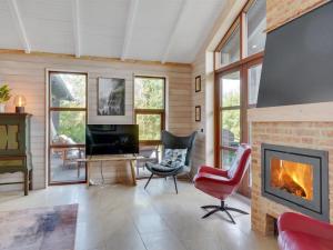 a living room with a fireplace and a tv at Holiday Home Andri - 600m to the inlet in The Liim Fiord by Interhome in Løgstør