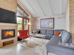 a living room with a couch and a fireplace at Holiday Home Andri - 600m to the inlet in The Liim Fiord by Interhome in Løgstør