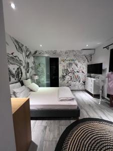 - une chambre avec un lit et un mur orné de plantes dans l'établissement PAP'S Chambres d'Hôtes, à Mahajanga