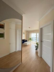 a room with a hallway with a door and a living room at Apartament Nr 50, 2 sypialnie, wygodny parking podziemny in Toruń