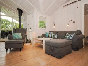uma sala de estar com um sofá, uma mesa e cadeiras em Holiday Home Evelina - 150m to the inlet in The Liim Fiord by Interhome em Løgsted