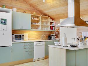 Holiday Home Magh in The Liim Fiord by Interhome في Års: مطبخ مع أجهزة بيضاء وسقوف خشبية