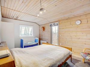 Holiday Home Magh in The Liim Fiord by Interhome في Års: غرفة نوم بسرير في غرفة بجدران خشبية