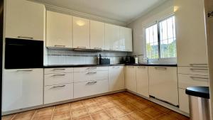 eine weiße Küche mit weißen Schränken und einem Fenster in der Unterkunft Roca de Leones by United Renters in El Campello