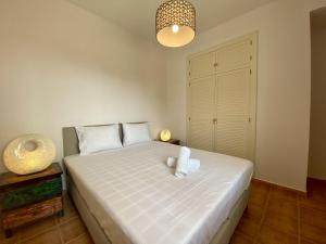ein Schlafzimmer mit einem großen weißen Bett mit einer Lampe in der Unterkunft Roca de Leones by United Renters in El Campello