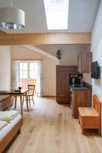 a living room with a table and a kitchen at Haus am Wald in Strobl