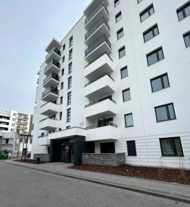 ein weißes Gebäude mit Balkon auf der Seite in der Unterkunft Apartament Nr 50, 2 sypialnie, wygodny parking podziemny in Toruń