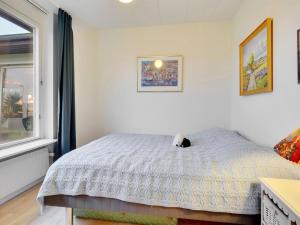 a bedroom with a bed with a cat sitting on it at Holiday Home Sirja - 250m from the sea in NE Jutland by Interhome in Hadsund