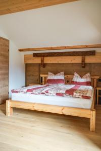 ein Schlafzimmer mit einem Holzbett in einem Zimmer in der Unterkunft Pension Haus am Wald in Strobl