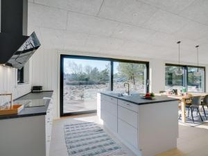 eine Küche mit weißen Schränken und einem großen Fenster in der Unterkunft Holiday Home Vigga - 800m from the sea in NW Jutland by Interhome in Fjerritslev