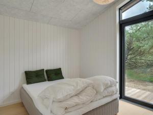 Schlafzimmer mit einem Bett mit weißer Bettwäsche und einem Fenster in der Unterkunft Holiday Home Vigga - 800m from the sea in NW Jutland by Interhome in Fjerritslev
