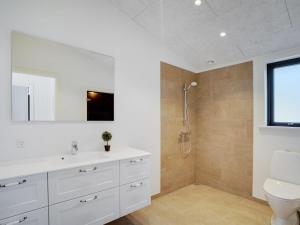 ein Badezimmer mit einem weißen Waschbecken und einem WC in der Unterkunft Holiday Home Vigga - 800m from the sea in NW Jutland by Interhome in Fjerritslev