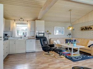 eine Küche und ein Wohnzimmer mit einem Sofa und einem Tisch in der Unterkunft Holiday Home Anselma - 800m to the inlet in The Liim Fiord by Interhome in Farsø