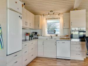 eine Küche mit weißen Schränken und einem Fenster in der Unterkunft Holiday Home Anselma - 800m to the inlet in The Liim Fiord by Interhome in Farsø