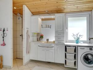 ein Badezimmer mit einem Waschbecken und einer Waschmaschine in der Unterkunft Holiday Home Anselma - 800m to the inlet in The Liim Fiord by Interhome in Farsø