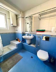 a blue bathroom with a toilet and a sink at La Gare Apartment in Varna City
