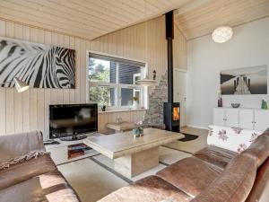 een woonkamer met een bank en een tv bij Holiday Home Anethe - 100m to the inlet in The Liim Fiord by Interhome in Løgstør