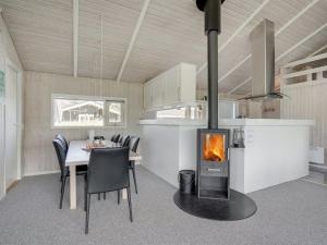 uma cozinha e sala de jantar com lareira numa casa em Holiday Home Serine - 800m from the sea in NW Jutland by Interhome em Hjørring