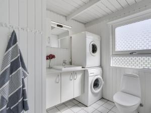 uma casa de banho branca com uma máquina de lavar roupa e um lavatório em Holiday Home Serine - 800m from the sea in NW Jutland by Interhome em Hjørring