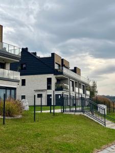 a building with a fence in front of a yard at Apartament Hawkinsa in Jelenia Góra +14 photos
