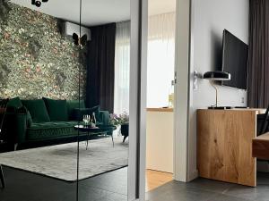 a living room with a green couch and a table at Apartament Hawkinsa in Jelenia Góra
